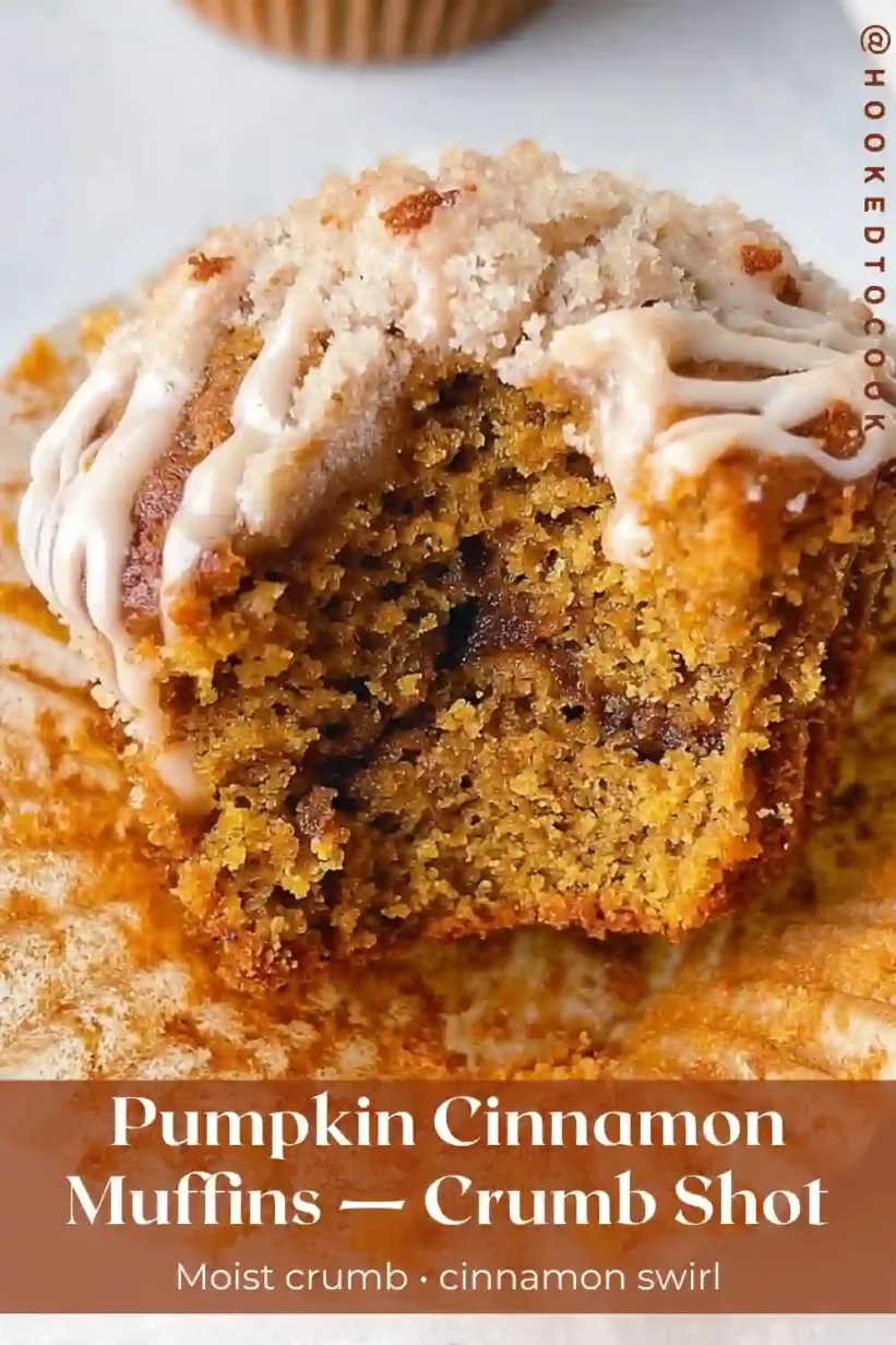 pumpkin cinnamon roll muffins cut open with moist crumb, cinnamon swirl and light glaze