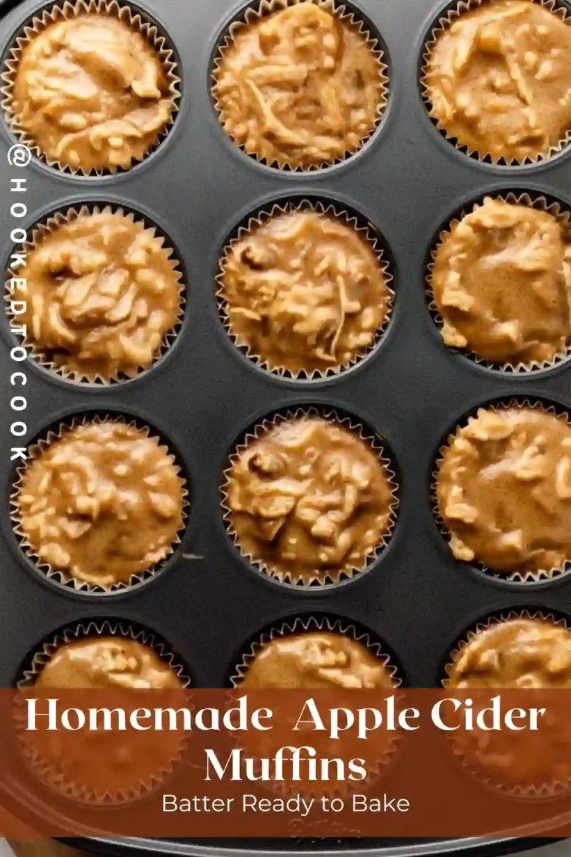 apple cider muffin batter in paper liners inside a non-stick muffin pan before baking