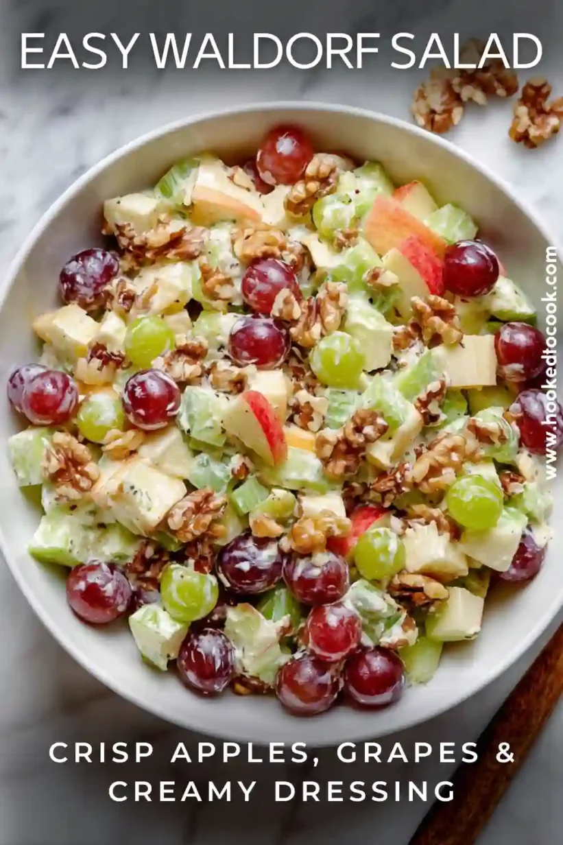 Waldorf Salad creamy apples grapes celery and walnuts in a white bowl.