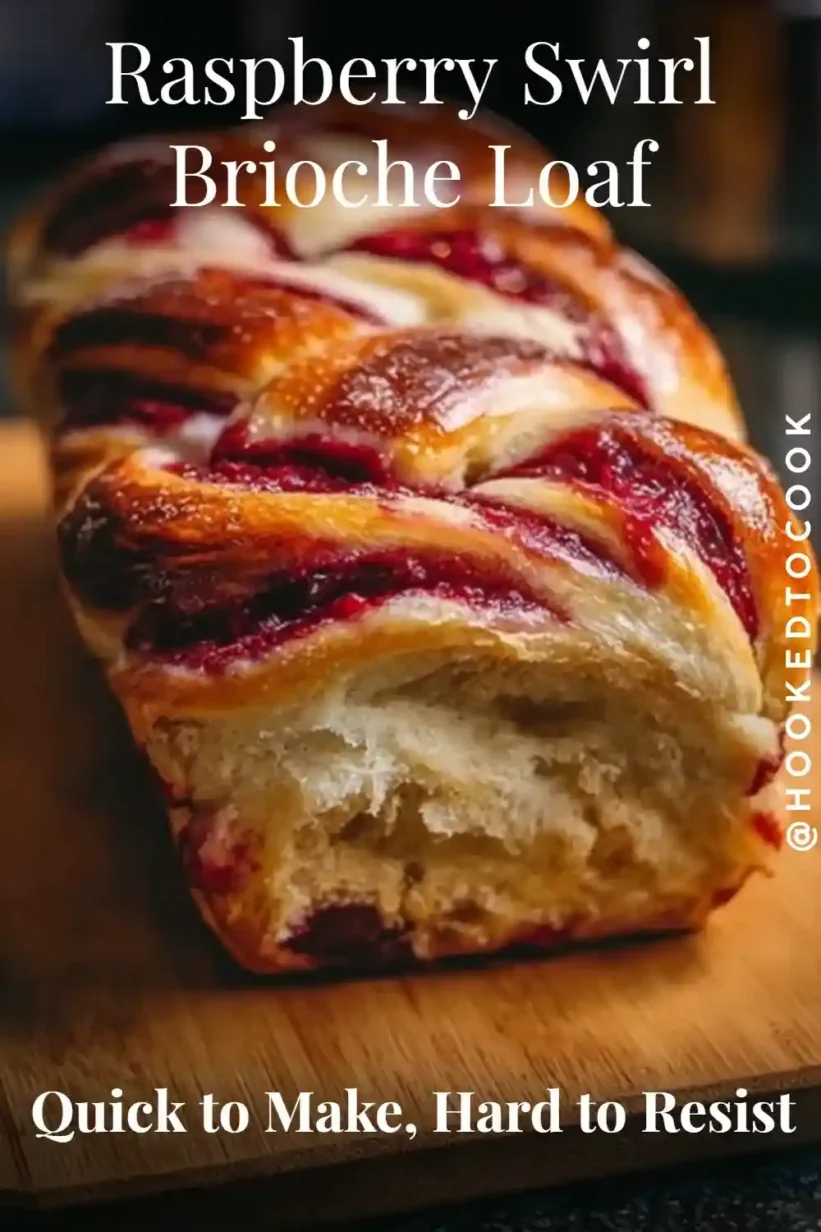 Raspberry swirl brioche loaf with golden crust and visible raspberry filling, braided and glossy