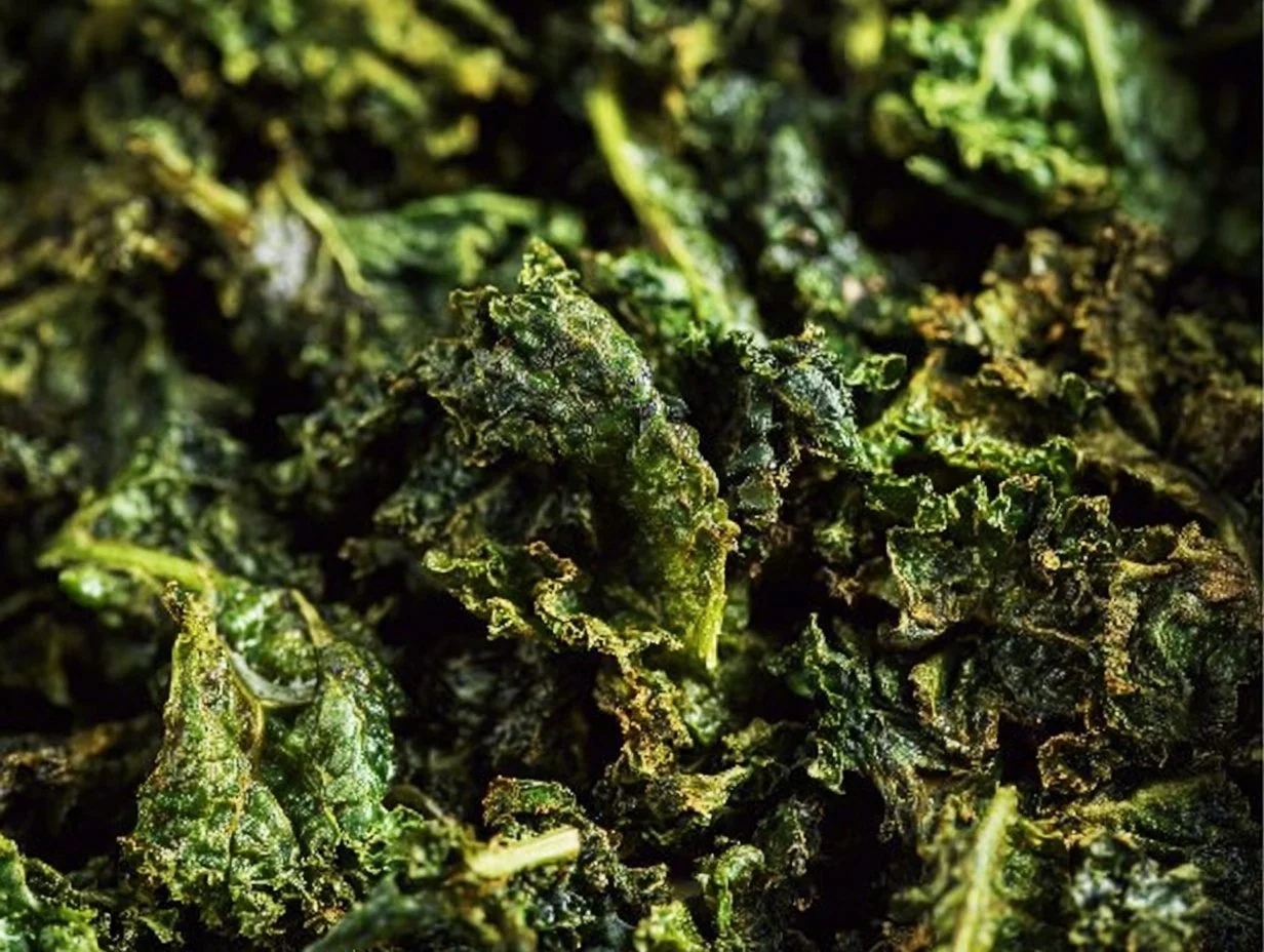 Baked kale chips served in a bowl topped with sea salt