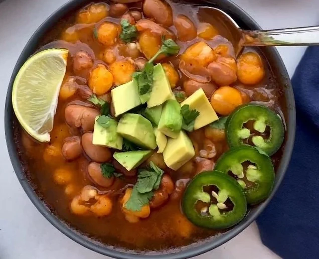 Bowl of hearty pinto bean soup with fresh herbs and spices