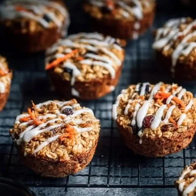 Carrot Cake Oatmeal Cups on a plate, garnished with nuts and frosting