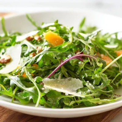Fresh arugula salad topped with lemon vinaigrette dressing.