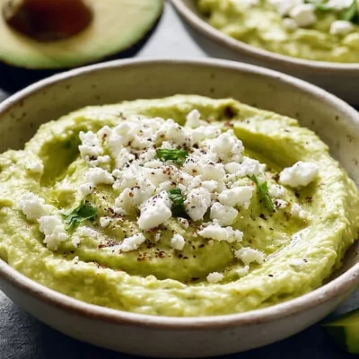 Creamy avocado feta dip served in a bowl with fresh vegetables for dipping
