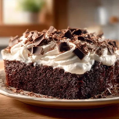 Delicious Chocolate Tres Leches Cake topped with whipped cream and chocolate shavings
