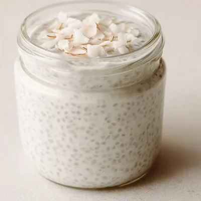A bowl of creamy coconut chia pudding topped with fresh fruit and coconut flakes