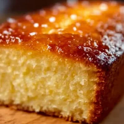 Slice of delicious lemon yogurt cake on a plate with fresh lemon slices.