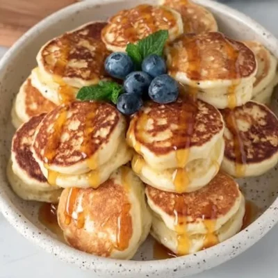 Fluffy lemon pancakes stacked with a slice of lemon on top