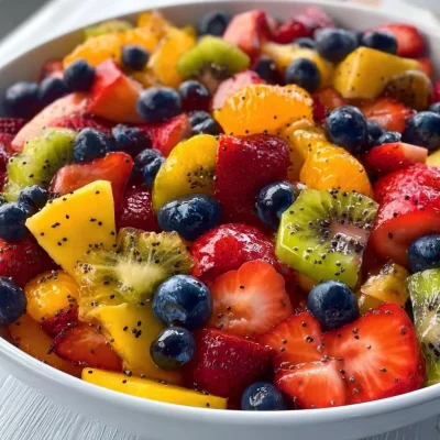 Fresh fruit salad with honey lime poppy seed dressing in a serving bowl