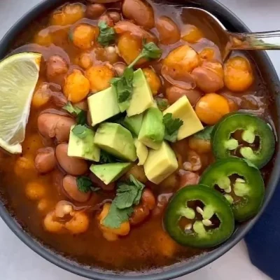 Bowl of hearty pinto bean soup with fresh herbs and spices