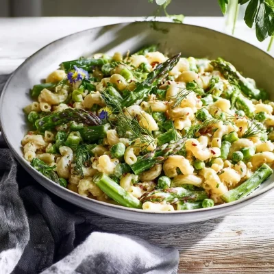 Lemon-Dijon Asparagus and Pea Macaroni Salad served in a bowl