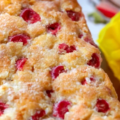 Slice of moist Lemon Rhubarb Bread with fresh rhubarb pieces and a citrus glaze.