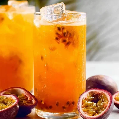 Refreshing Passionfruit Tea in a clear glass with tropical fruits