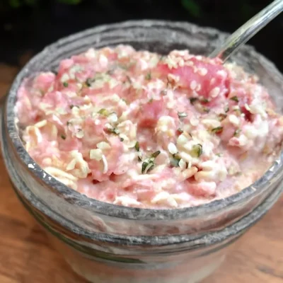 Bowl of Rhubarb Overnight Oats topped with fresh fruit and nuts.