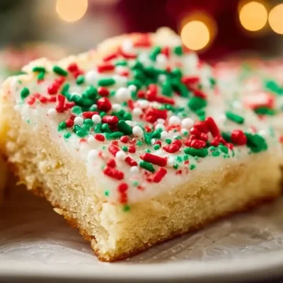 Delicious Christmas sugar cookie bars topped with colorful sprinkles.