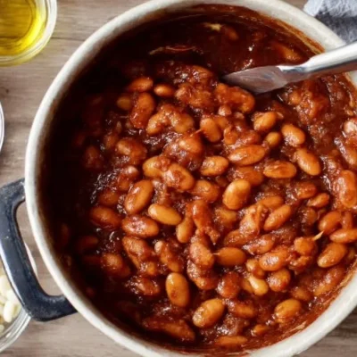 A bowl of flavorful vegetarian baked beans recipe, garnished with herbs.